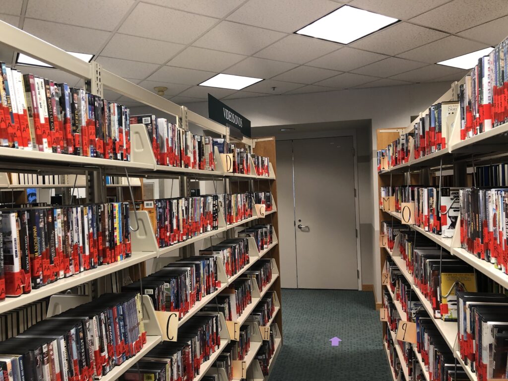 Giovale rentals on shelves in the library.