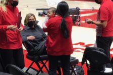 Malia Shoji works while holding her baby at the Huntsman Center.