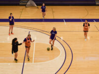 Griffin women’s soccer team players pause and talk during their off-season practice on a basketball court.