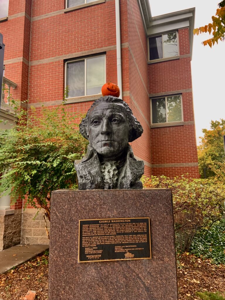 George Washington’s bust is shown outside of the residential parking lot with a small jack-o-lantern on top of his head.
